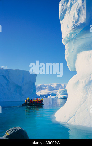 Les touristes en croisière gonflable passé icebergs, Antarctique Banque D'Images