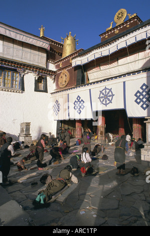 Pèlerins bouddhistes tibétains se prosternant devant le temple de Jokhang, à Lhassa, Tibet, Chine, Asie Banque D'Images