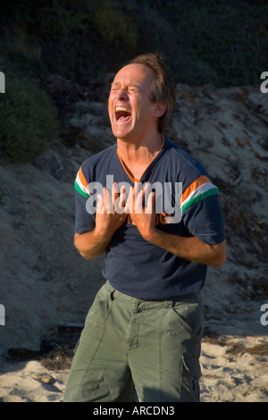 Le chef d'un club de yoga du rire est un exemple pour ses membres qu'ils répondent par le bord de mer à Laguna Beach en Californie Banque D'Images