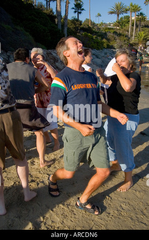 Le chef d'un club de yoga du rire est un exemple pour ses membres qu'ils répondent par la mer dans Laguna Beach CA Banque D'Images