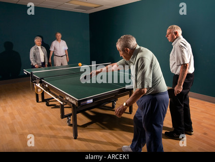 Les hommes âgés et les femmes âgées de leur 70 s pour leur 90 s jouer ping pong Banque D'Images