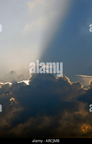 Soleil du soir de derrière les nuages et la projection de la banque plus de rayons le ciel Banque D'Images