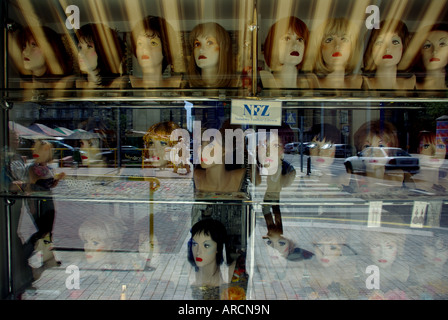 Vingt-trois têtes de mannequins de vitrine une perruque à Poznan, Pologne. Rue montre verre réflexions. Banque D'Images