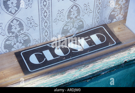 Close up of sign in Art déco indiquant lettrage sur Fermé d'écaillage de bas de châssis de fenêtre avec rideau à motifs derrière Banque D'Images