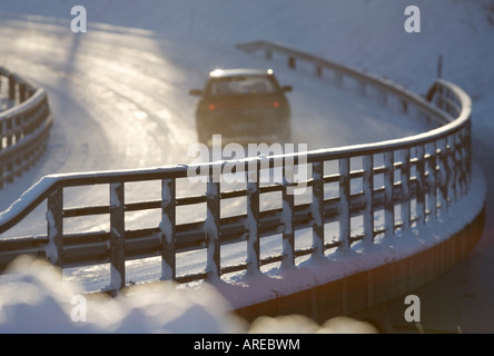 Route enneigée métalliques garde-corps de pont et les conducteurs de voitures sur la route à l'hiver , Finlande Banque D'Images