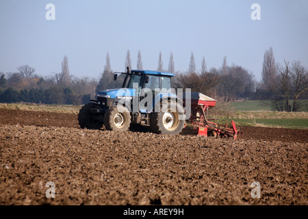 Les semis des céréales d'été à l'aide d'un tracteur Ford New Holland et Accord Ferrag semoir pneumatique du Suffolk, UK Banque D'Images