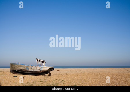 Vieux bateau de pêche à l'ouest sur une plage de galets à Dungeness, Kent, en été ciel bleu jour Banque D'Images