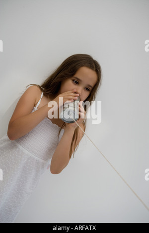 Fille à l'aide d'une boîte en fer blanc comme un téléphone Banque D'Images