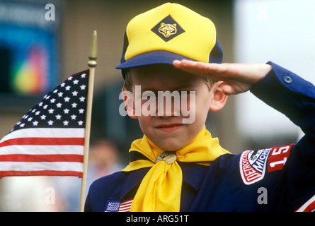 American Louveteau salue comme il est titulaire d'un drapeau américain Banque D'Images