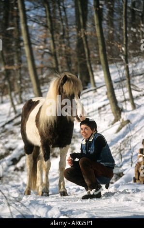 Une fille et un cheval islandais sur un chemin enneigé Banque D'Images