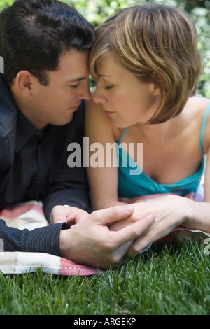 Couple Lying on Grass Banque D'Images