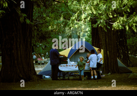 Une famille a installé une tente et prépare un pique-nique dans un camping dans le Parc National de Yosemite en Californie. Banque D'Images