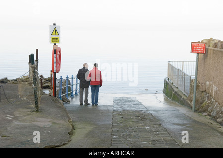 Couple sur la cale regardant la mer Banque D'Images