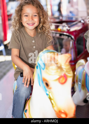 Petite fille sur merry go round Banque D'Images