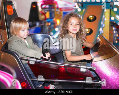 Peu de filles sur merry go round Banque D'Images