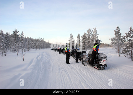 Groupe avec des motoneiges en profitant de la vue près de Levi dans le Nord de la Finlande Laponie Cercle Arctique Banque D'Images