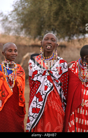 Les femmes masaï dans leur village montrant leurs costumes colorés, colliers et boucles d'oreilles et le chant. Banque D'Images