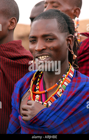 Un portrait d'un guerrier Masaï Moran, en vêtements tribaux, et avec de grandes boucles d'oreille, souriant à la caméra. Banque D'Images