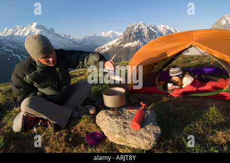 Mid adult man de préparer des aliments au cours de camping and reposant dans une tente, Aiguilles Rouges, Chamonix, France Banque D'Images