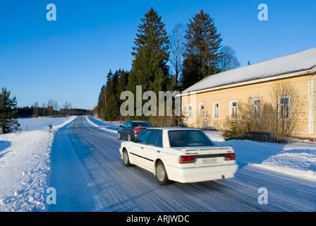 Voiture blanche conduite sur route glacée glissante au Winter , Finlande Banque D'Images