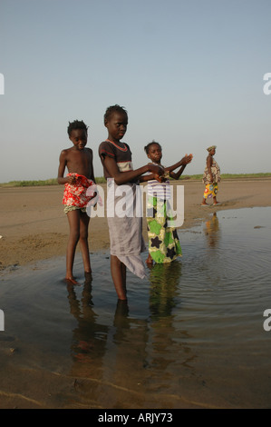 Les filles à la recherche de crabes à la fin de la journée de l'Afrique de l'ouest de la Gambie Banque D'Images