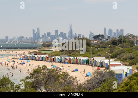 Cabines de plage, la plage de Brighton, Brighton, et en arrière-plan des gratte-ciel de la ville de Melbourne, Victoria, Australie Banque D'Images