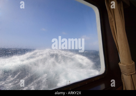 Vue depuis la cabine de l'Antarctic Dream navigation dans une mer agitée près du cap Horn, le Passage de Drake, l'océan Antarctique Banque D'Images