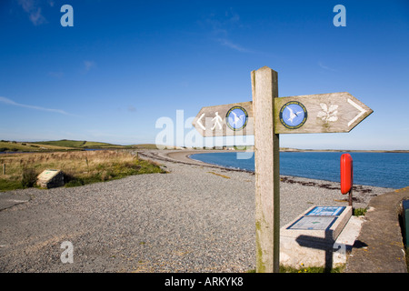 ISLE OF ANGLESEY COASTAL PATH signe avec logo pointant vers l'ouest le long de la plage de galets à Cemlyn Bay North Wales Anglesey Banque D'Images