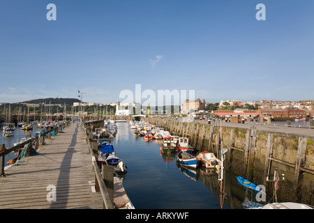 Jetée en bois bateaux amarrés au port de plaisance avec phare de South Bay Scarborough North Yorkshire Angleterre Royaume-uni Grande-Bretagne Banque D'Images