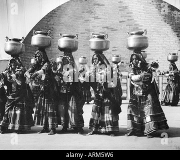 Les femmes en costume traditionnel indien de l'acier dans des pots de l'eau holding head Banque D'Images