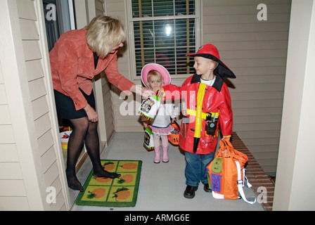 Les enfants s'habillent en costumes colorés et du porte-à-porte et la mendicité des friandises à l'Halloween Banque D'Images