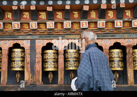 Vieux homme bhoutanais en tournant les roues de prière dans un temple bouddhiste, Thimphu, Bhoutan, Asie Banque D'Images
