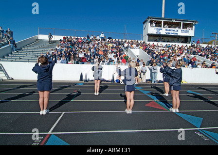 High School cheerleaders complexe et parfois effectuer des manœuvres dangereuses au cours de la présentation à un match de football Banque D'Images