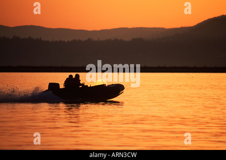 Petit bateau gonflable, coucher du soleil, en Colombie-Britannique, Canada. Banque D'Images