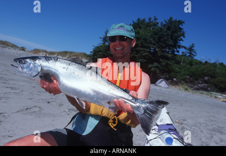 La kayakiste dispays coho capturés frais sur Whaler Island, Clayoquot, île de Vancouver, Colombie-Britannique, Canada. Banque D'Images