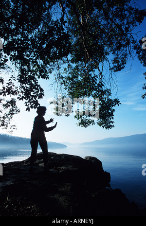 Seule femme praticing Tai Chi sur la côte, l'île de Vancouver, Colombie-Britannique, Canada. Banque D'Images