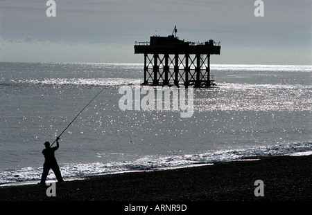 Sa ligne de pêche pêcheur casting de la plage, de Sizewell, Suffolk, UK. Banque D'Images