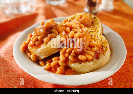Les haricots et les saucisses sur les crumpets a servi de repas sur une plaque blanche dans une table Banque D'Images