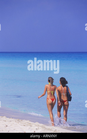 Cuba, Veradaro, deux jeunes femmes les visiteurs à pied vers le bas du bord des océans. Banque D'Images
