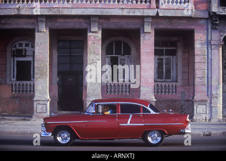 Voiture classique en face de bâtiments anciens sur le Malecon au bord de Barrio Chino, La Havane, Cuba. Banque D'Images