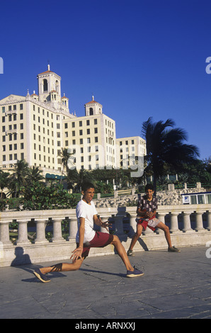 Cuba, La Havane, l'hôtel Nationale garçons jouer au ballon près de Malecon. Banque D'Images