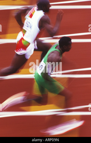 Deux coureurs dans le motion blur sur piste de couleur rouille. Banque D'Images