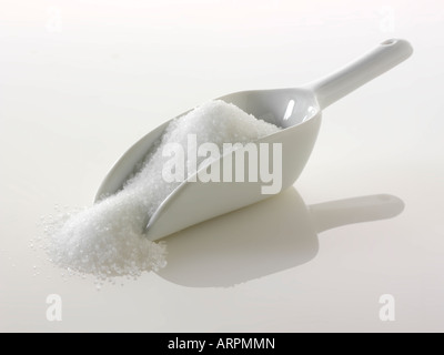 Sucre blanc granulé sur un fond blanc. Banque D'Images