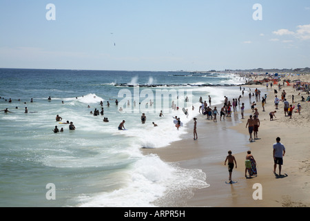 Rivage de sable à partir de ci-dessus. Les gens marcher et jouer le long de la ligne de surf avec de petites vagues se brisant sur shore moussant Banque D'Images