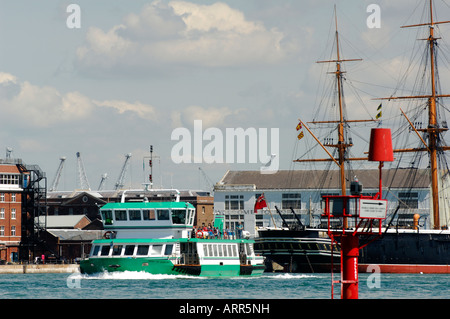 Le gosport ferry faire son chemin à travers le port de Portsmouth avec hms wario et victoire dans le contexte lors du chantier naval historique Banque D'Images