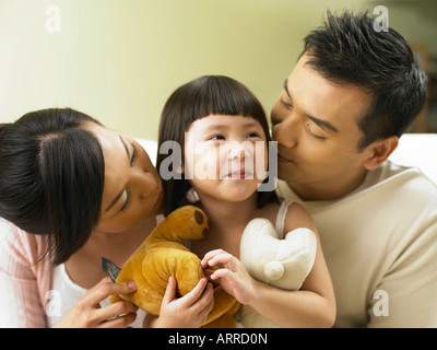 Les parents s'embrasser leur fille Banque D'Images