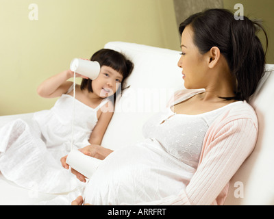 Girl écouter bébé dans le ventre de mom Banque D'Images