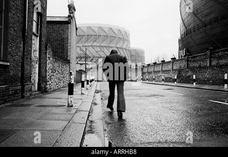 L'homme dans une rue de Londres du sud (Bédoin) à la fin des années 1970/début des années 1980, à marcher avec ses mains dans ses poches. Banque D'Images