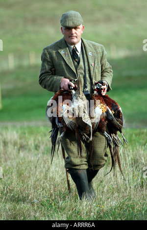 Garde-chasse avec sac du jour accolades de faisans anglais scène rurale Banque D'Images