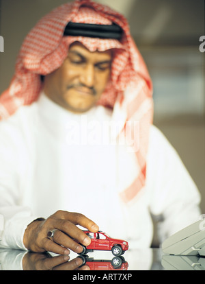 Homme jouant avec une petite voiture Banque D'Images